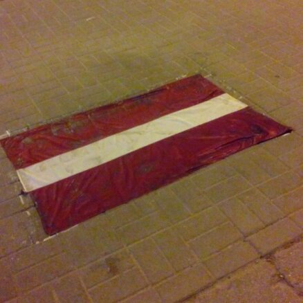Rīgas centrā ar līmi uz ielas pielīmēts un samīdīts Latvijas karogs