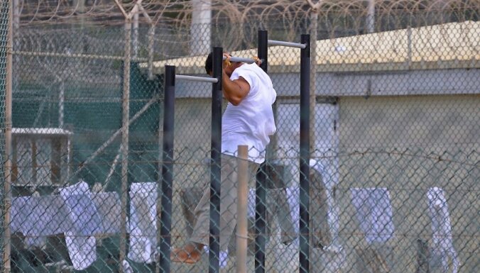epa02134071 In this photo, reviewed by a U.S. Department of Defense official, a Guantanamo detainee does pull-ups inside an exercise area at the detention facility at Guantanamo Bay U.S. Naval Base, Cuba, 27 April 2010.  EPA/Michelle Shephard / POOL POOL